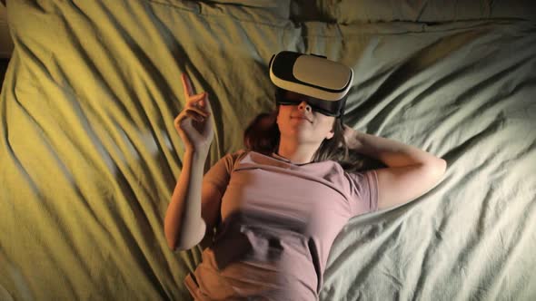 Woman Is Lying in Bed in Virtual Reality 3d Glasses and Swiping By Hand in Air