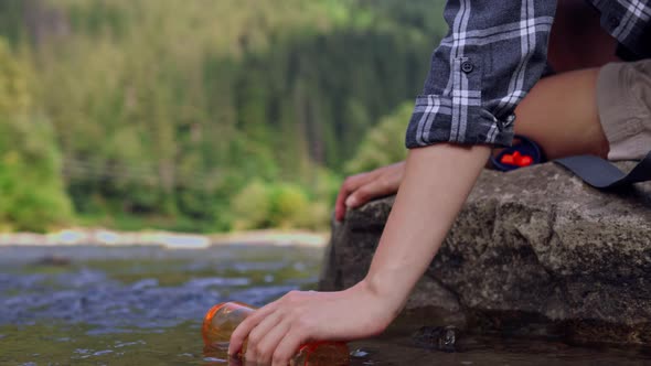 A Young Girl Tourist Draws Water From A Flowing Stream A Hiker Draws Water Into A Sports Bottle From alt