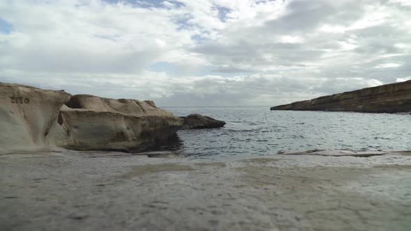 Low Angle Shot of St Peters Pool Stone Beach Shoreline with Mediterranean Sea in Background alt