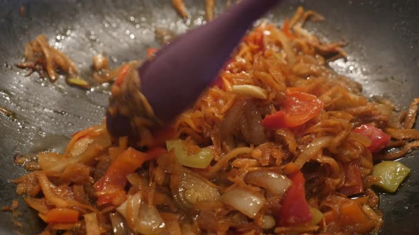 Frying of bulb onion and grated carrot 4K 2160p 30fps UltraHD footage - Frozen vegetable mix  in hot alt