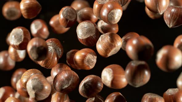 Super Slow Motion Closeup Shot of Flying Whole Hazelnuts Towards Camera on Black at 1000Fps alt