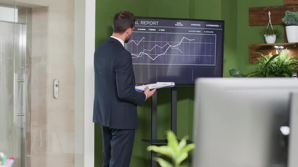 Dolly Shot of Caucasian Office Worker Analyzing Annual Report Data alt