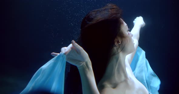 Close-up Portrait of the Face of a Dark-haired Girl with Rhinestones on Her Face Who Is Underwater alt