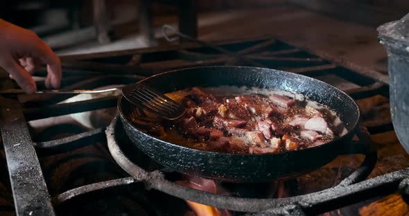 Frying Meat in Pan on the Opened Fire at Fireplace in House Inside Indoors alt