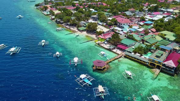 Tourists Swimming Around Bangka Boats Floating On Crystal Clear Blue Water In Moalboal Cebu alt