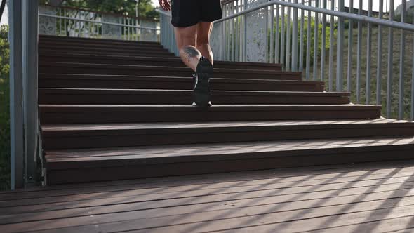 Sportive Athlete Runs Fast on Wooden Stairs on Sunny Day alt