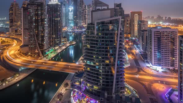 Aerial View of Dubai Marina Residential and Office Skyscrapers with Waterfront Night to Day alt