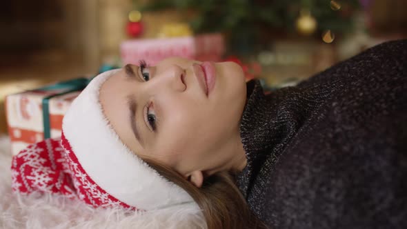 Woman with Christmas hat lying on the floor alt