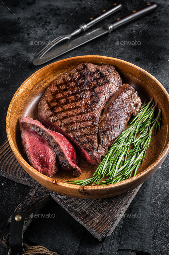 BBQ Grilled Medium Rare top sirloin beef steak, rump steak in a wooden plate. Stock Photo by