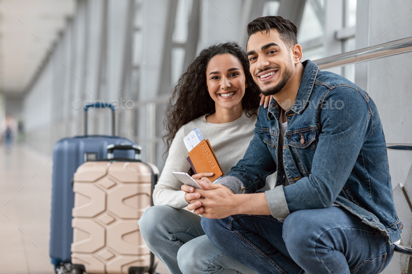 Couple In Airport Happy Man And Woman Waiting For Flight At Terminal