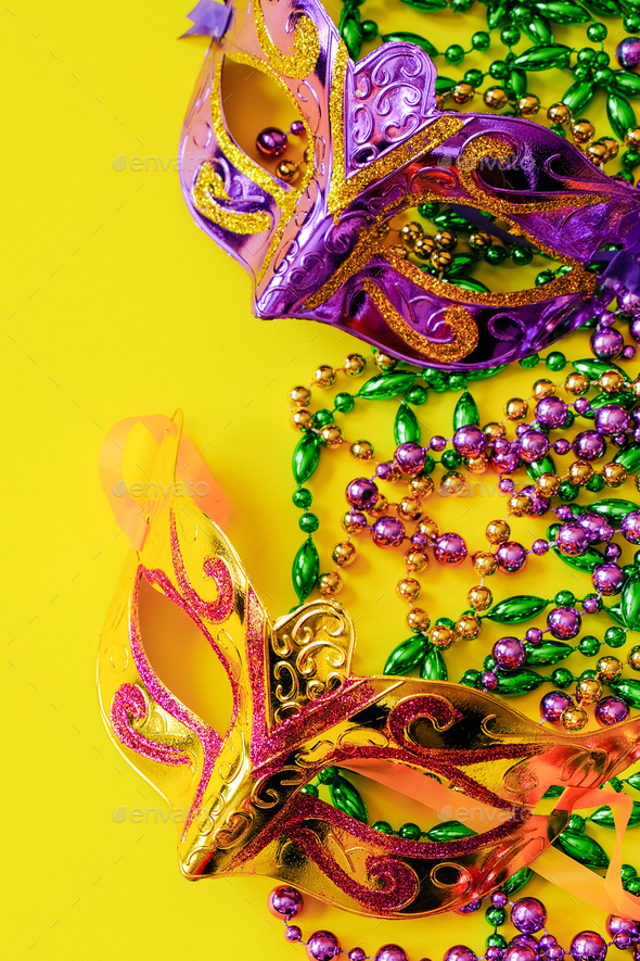 Two carnival masks on yellow background. Mardi Gras or Fat Tuesday symbol.