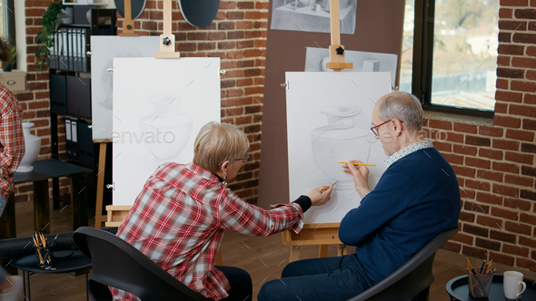 Senior man and woman at community centre drawing vase model
