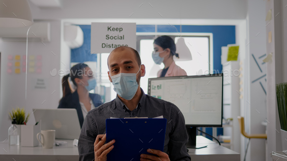 Pov of businessman in face mask to avoid infection talking on online video call conference