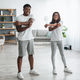 Young black couple doing arm stretch exercise together at home - PhotoDune Item for Sale