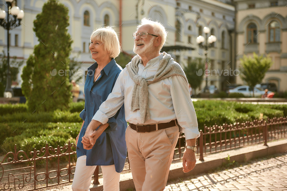 True love has no expiration date. Happy and beautiful elderly couple holding hands while walking