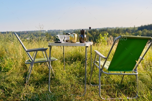 Set of folding furniture for camping, table and chair, summer nature of wild meadow