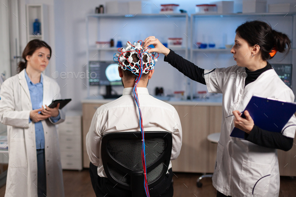 Medical Team Of Neurologists Adjusting Brain Eeg Analyzing Nervous ...