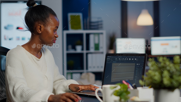 Black woman engineer designer looking at laptop analysing project