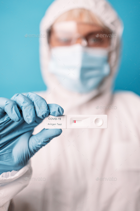 Doctor in blue gloves holding rapid antigen test kit - Stock Photo - Images