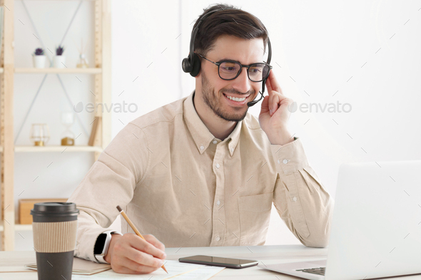 Guy from technical customer service support answering voice calls from clients in office