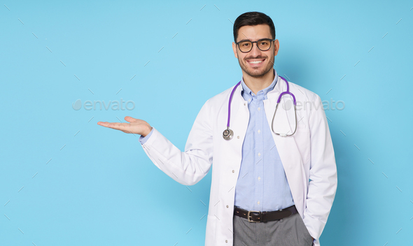 Horizontal banner of smiling young male doctor showing commercial offer with hand