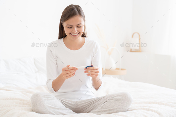 Young lady feeling happy about getting pregnant that she learnt from pregnancy test