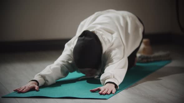 Yoga Indoors  Young Woman in Hijab Doing Exercises on Yoga Mat alt