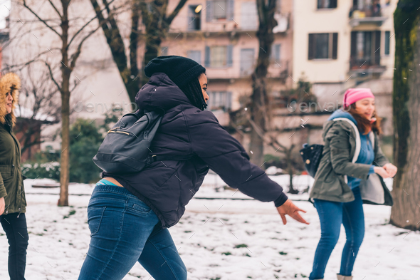 three young women multiethnic playing snow ball fight
