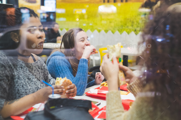 group of young women eating together in fast food
