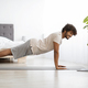 Happy athletic hindu man planking at home, using laptop - PhotoDune Item for Sale