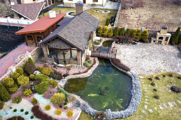 Aerial view of beautifully landscaped recreation house cottage complex with pond in ecological area