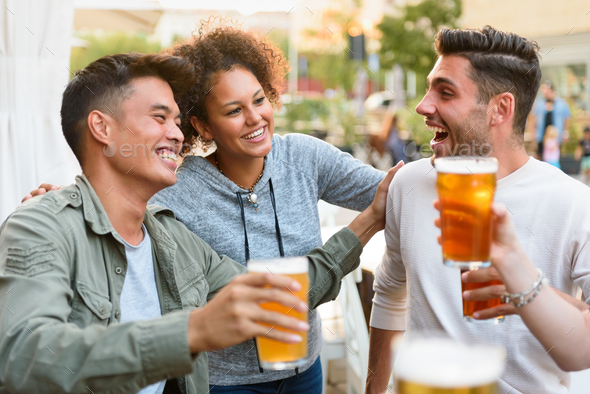 Happy multiethnic friends drinking beer
