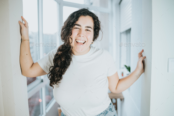 Young woman with long hair portrait smiling and having fun on a modern city flat. Life at the city