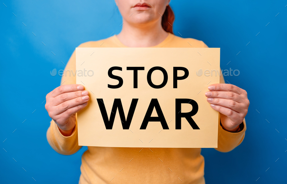 No more war. Woman hands holding banner with inscription stop war, protesting on a blue background