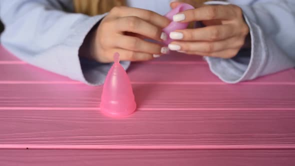 Close Up Menstrual Cup Latex Silicone Girl Looking Holding Hands Compress Folding alt