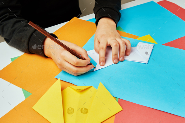 Boy making paper dog origami