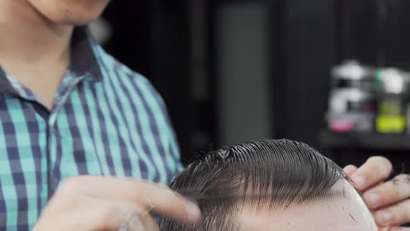 Cropped Shot of a Hairstylist Combing Wet Hair of a Client