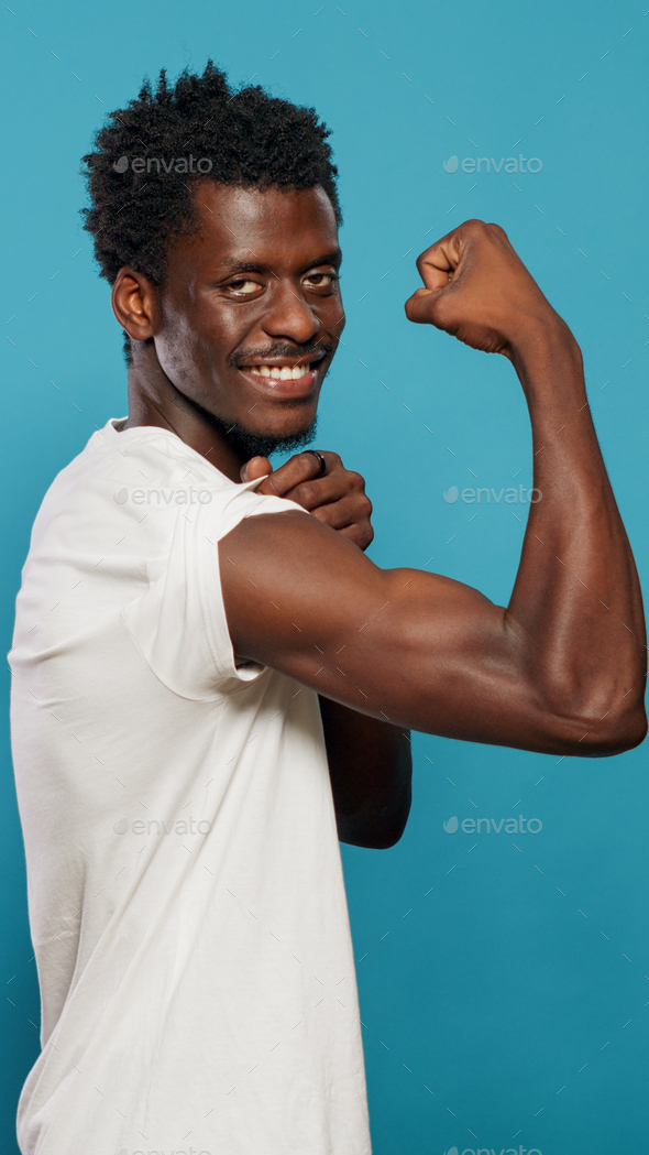 Fit man showcasing muscular arms. Studio portrait on white