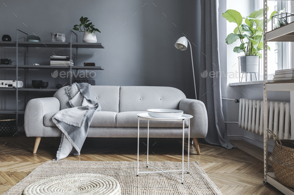 Stylish nordic living room with design grey sofa and coffee table.