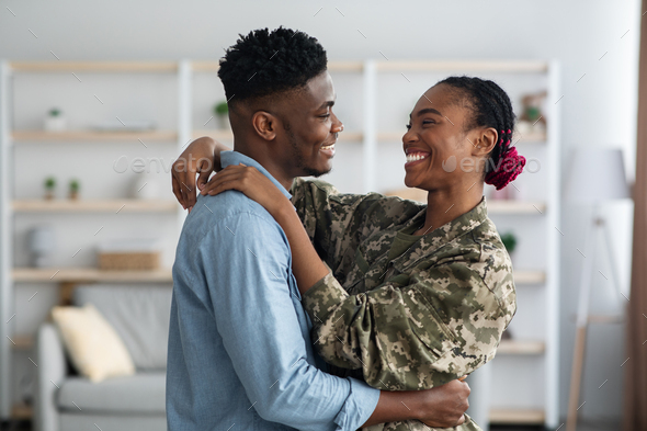 Loving black family military wife and husband embracing at home
