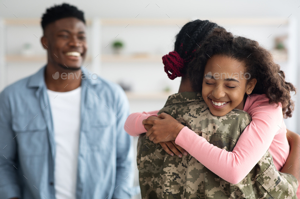 Happy black family greeting mother soldier back from army