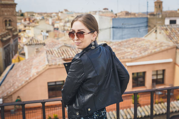 Stylish woman posing in the old part of the town against tile roofs. Medieval city of Toledo in the - Stock Photo - Images