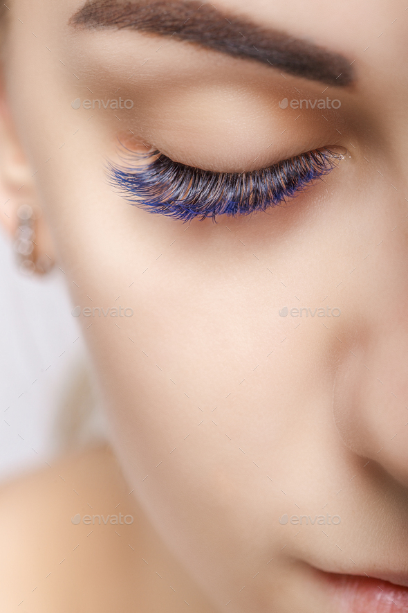 Eyelash Extension Procedure. Woman Eye with Long Blue Eyelashes. Ombre effect. Close up, selective - Stock Photo - Images