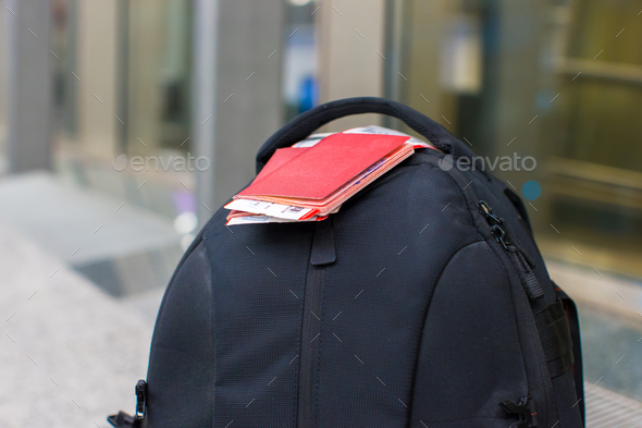 Closeup passports and boarding pass on backpack at airport - Stock Photo - Images
