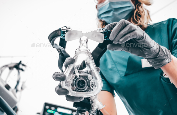 Nurse applies a mask of the mechanical ventilation machine