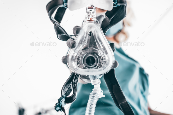 Nurse applies a mask of the mechanical ventilation machine.