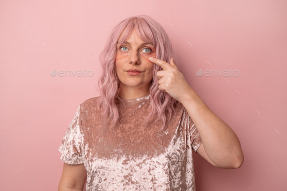 woman applying pink under eye patches for dark-circles and puffiness looking at the camera