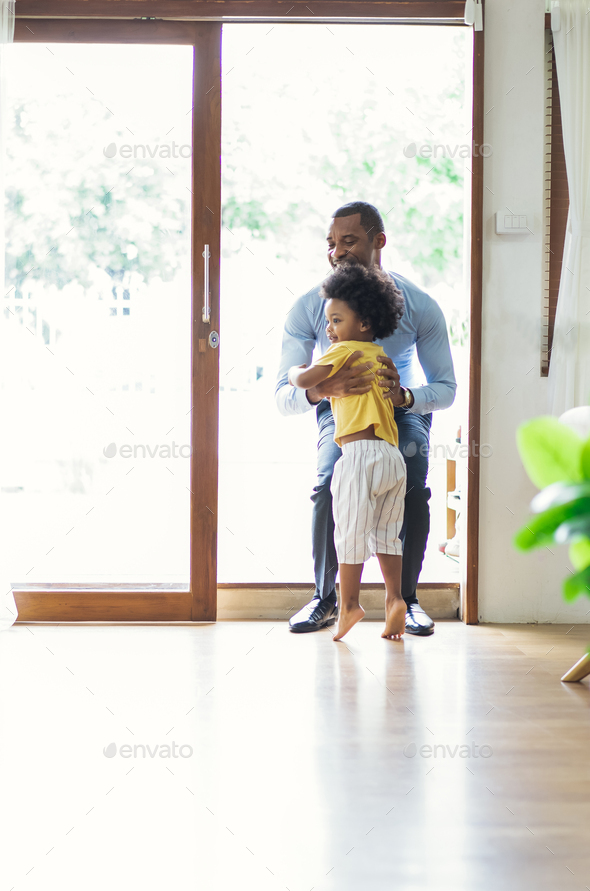 Happy family African American son running and hugging dad after going back from office