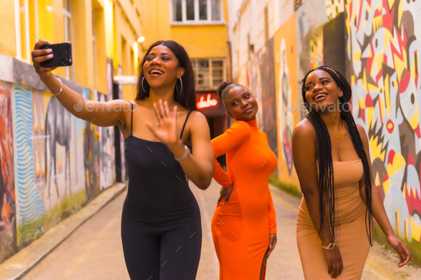 Fashionable urban style with three black African girls on a city street ...