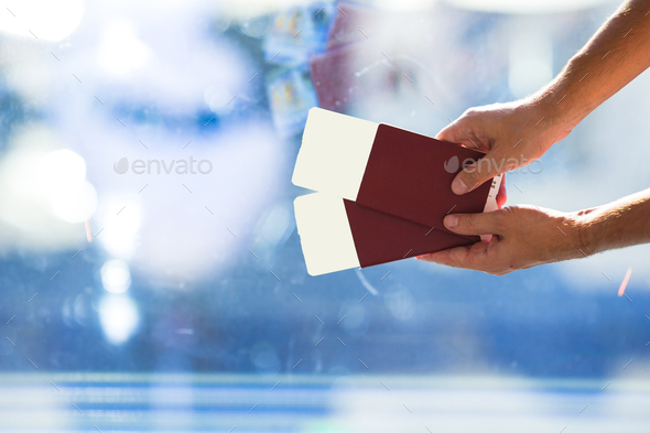 Closeup passports and boarding pass at airport indoor - Stock Photo - Images